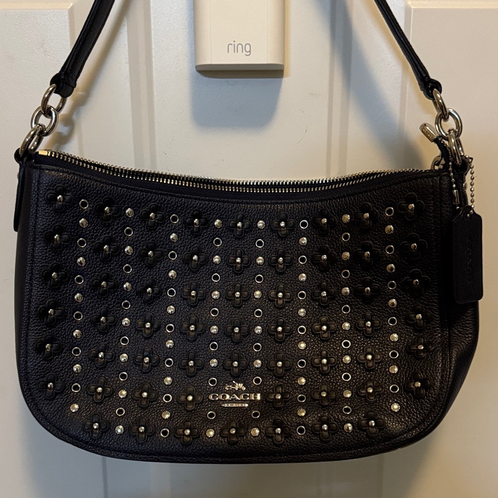 Coach Chelsea crossbody bag with floral rivets.